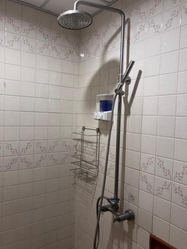 a shower in a bathroom with a shower head at Flourish Apartments Sukhumvit 39 in Bangkok