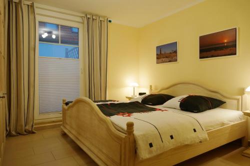 um quarto com uma cama grande e uma janela em Ibykus em Prerow
