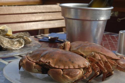 a large lobster sitting on a plate on a table at Logis Hôtel Restaurant le Printania in Dinard