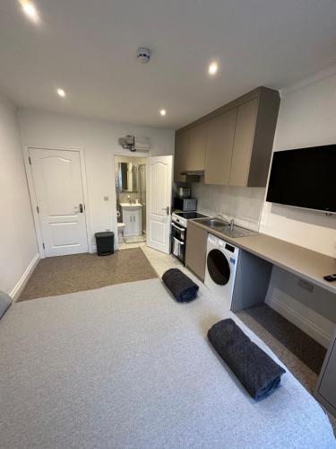 a living room with a kitchen with a counter top at Bright Modern, 1 Bed Flat, 15 Mins Away From Central London in Hendon