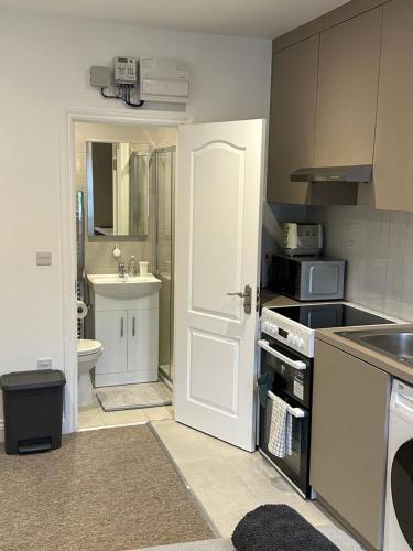 a kitchen with a white door and a sink at Bright Modern, 1 Bed Flat, 15 Mins Away From Central London in Hendon