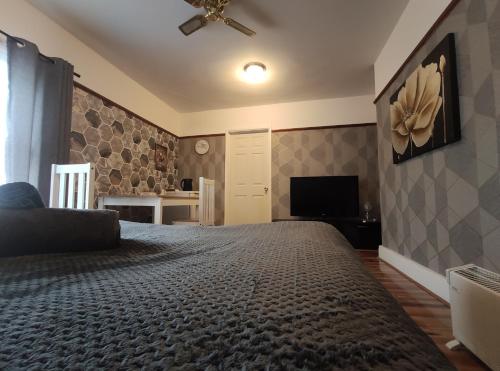 a bedroom with a large bed and a flat screen tv at Bright Park Inn in Peterborough