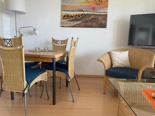 a dining room with a table and chairs and a tv at Likedeeler Weg 1 Whg 21 in Zingst