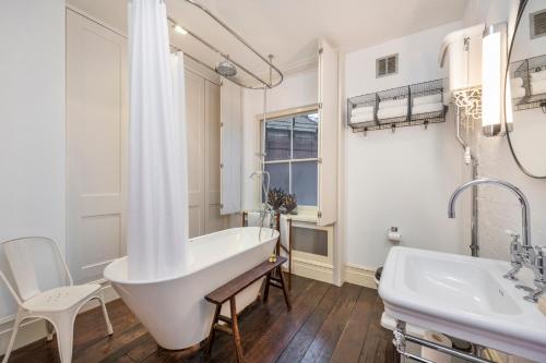 a white bathroom with a tub and two sinks at A Starry Starry Night - Borough - by Frankie Says in London