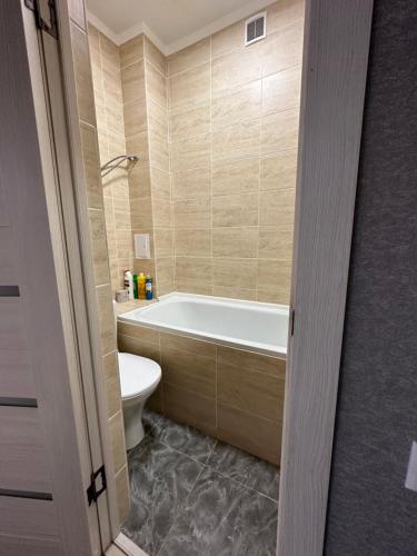 a bathroom with a bath tub and a toilet at 1 комн.квартира in Balqash