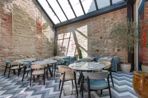 een kamer met tafels en stoelen en een bakstenen muur bij La Fonda Heritage Hotel Luxury, Relais & Châteaux in Marbella