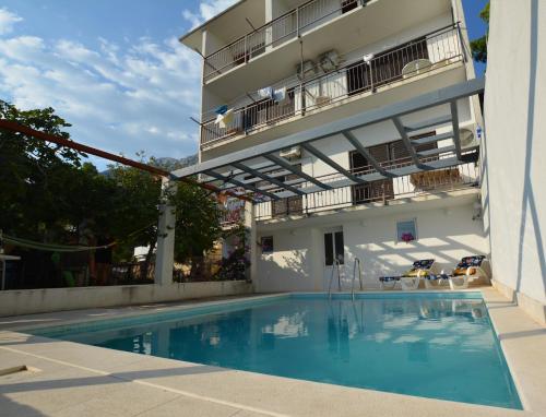 a swimming pool in front of a building at Entire home with a swimming pool for 12 in Marusici in Marusici 