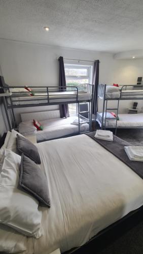 a bedroom with three bunk beds and a window at Y Gwynedd Inn in Llanberis