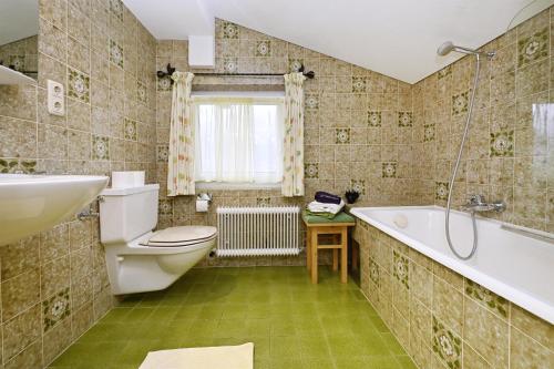a bathroom with a tub and a toilet and a sink at Gästehaus Rundblick in Schruns