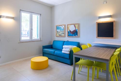 a living room with a blue couch and a table at Golfo del Sole Hotel & Holiday Resort in Follonica