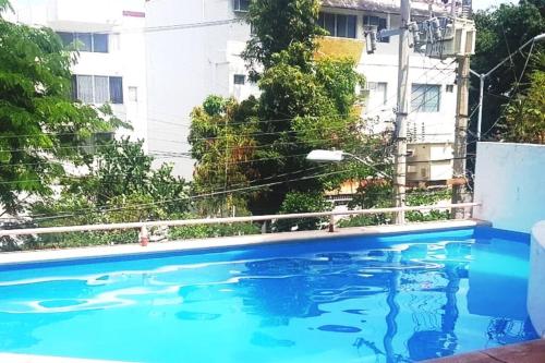 a blue swimming pool in front of a building at Lujoso Departamento en Zona Dorada de Acapulco in Acapulco