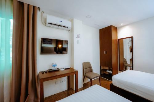 a hotel room with a bed and a desk and a bed at Emerald Boutique Hotel in Legazpi