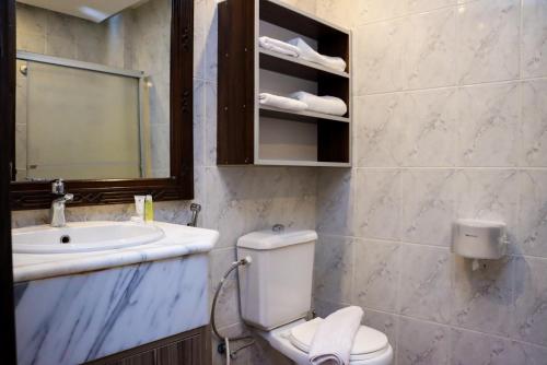 a bathroom with a toilet and a sink and a mirror at The RN Hotels in Wadi Musa