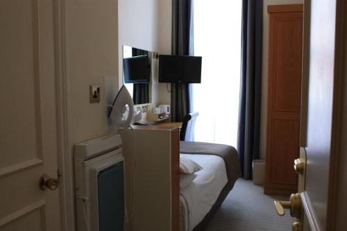 ein Hotelzimmer mit einem Bett und einem Fenster in der Unterkunft Regency Hotel Westend in London
