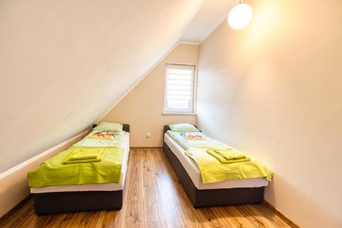 twee bedden in een kleine kamer met een raam bij Domek na Kaszubach na Gwizdowce in Załakowo