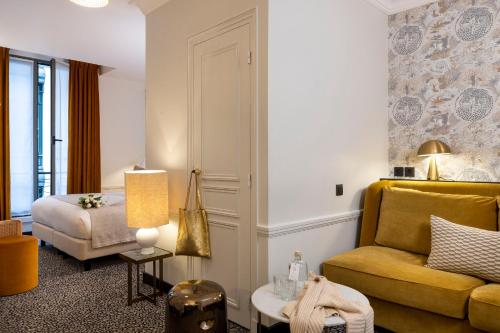 a living room with a couch and a bed at Hôtel Gramont in Paris