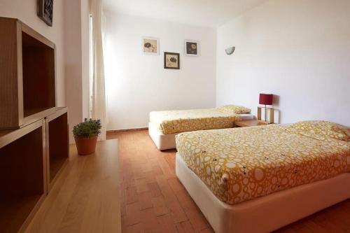 een slaapkamer met twee bedden en een flatscreen-tv bij apartment with breathtaking view in Burgau