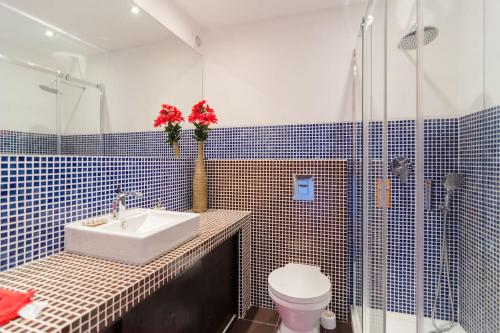 een badkamer met een wastafel, een toilet en een douche bij apartment with breathtaking view in Burgau