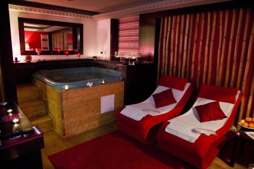 a bathroom with a tub and a red chair next to it at Phoenicia Grand Hotel in Bucharest