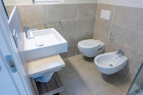 a bathroom with a white sink and a toilet at Golfo del Sole Hotel & Holiday Resort in Follonica