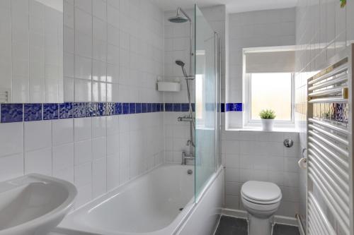 y baño con bañera, aseo y lavamanos. en Modern 1BR Gem - Stylish Flat in Harlow, en Great Parndon