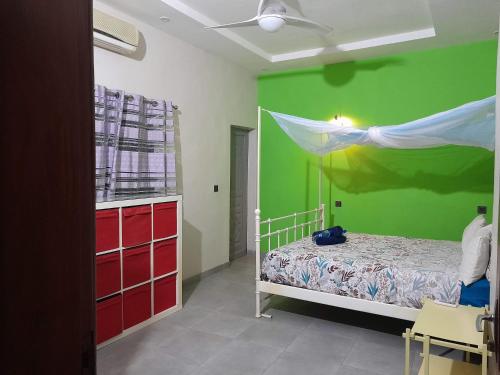 1 dormitorio con 1 cama con pared verde en Magnifique appartement, en Cotonou