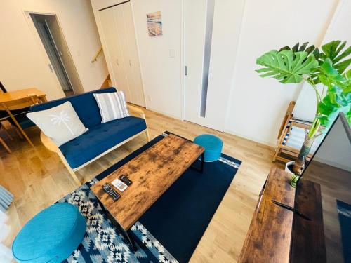 a living room with a table and a blue couch at Base in Onnason,Okinanawa in Onna