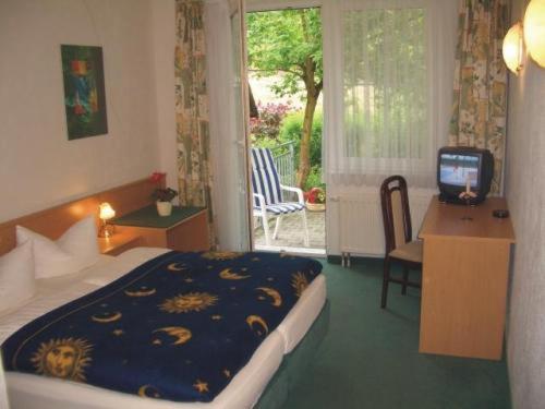 ein Hotelzimmer mit einem Bett und einem TV in der Unterkunft Waldhaus Mühlenbeck bei Berlin in Mühlenbeck