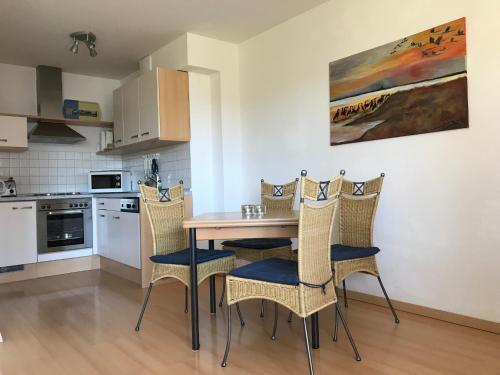 a kitchen with a table and chairs in a room at Likedeeler Weg 1 Whg 21 in Zingst