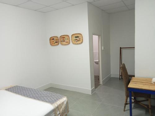 um quarto branco com uma cama e uma mesa e uma mesa e cadeiras em Homestay Miền Biển Vĩnh Hy 2 em Vinh Hy