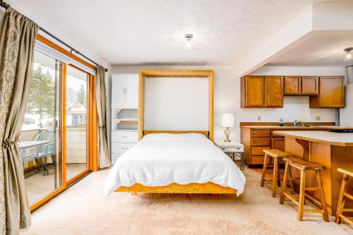 a bedroom with a bed and a kitchen at Timberline Getaway in Girdwood