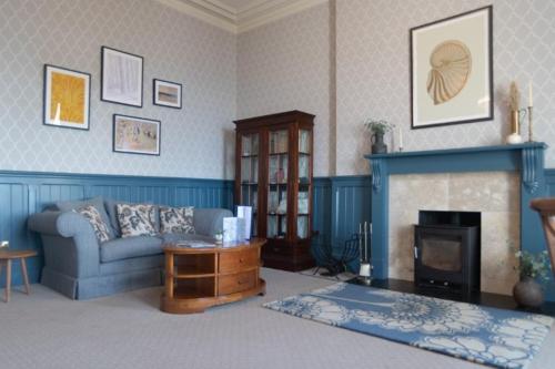 a living room with a couch and a fireplace at Mullion Cove Hotel & Spa in Mullion