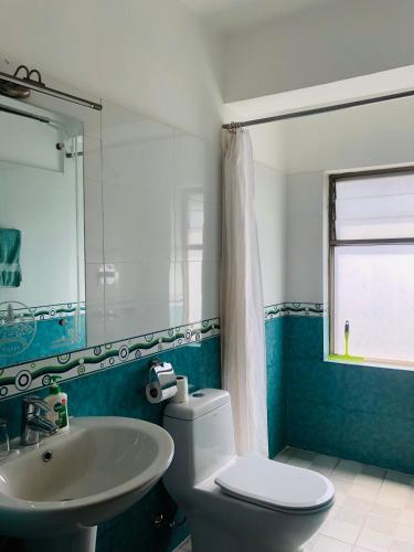 Un baño con un inodoro blanco y un lavabo. en Kathmandu View Hotel, en Katmandú