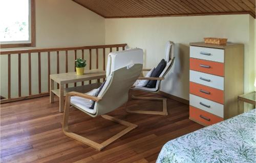 een slaapkamer met 2 stoelen, een bureau en een bed bij Casa El Rosedal in Ladrido