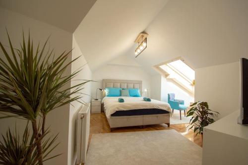 ノヴィサドにあるSpacious, central and luxury flat with great view!のベッドルーム1室(青い枕と植物付)