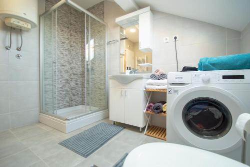 a bathroom with a washing machine and a shower at Spacious, central and luxury flat with great view! in Novi Sad