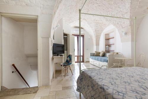 Schlafzimmer mit einem Bett, einem Schreibtisch und einem TV in der Unterkunft Dimora Bellargo by BarbarHouse in Martina Franca