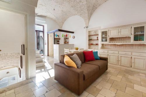 ein Wohnzimmer mit einem braunen Sofa in einem Zimmer in der Unterkunft Dimora Bellargo by BarbarHouse in Martina Franca