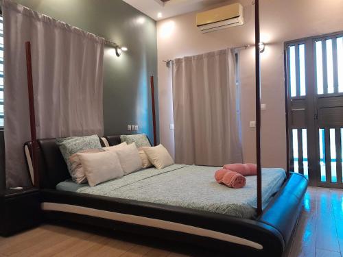 a bedroom with a canopy bed with pillows on it at Superbe appartement en résidence in Cotonou