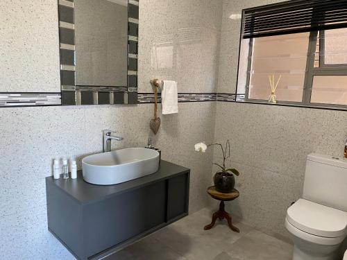 uma casa de banho com um lavatório e um WC em Tulip On The Bay em Mossel Bay