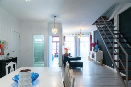 uma sala de jantar e sala de estar com uma escada em espiral em Porto River House no Porto