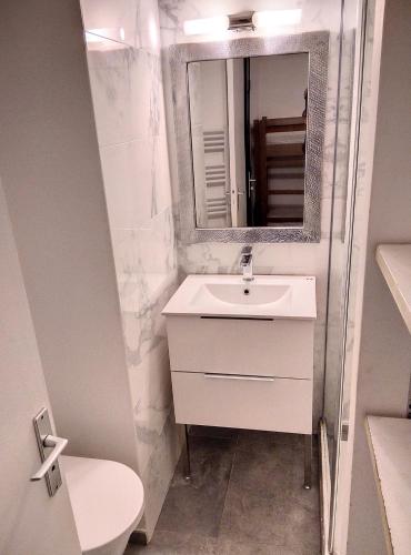 une salle de bain blanche avec un lavabo et un miroir dans l'établissement Résidence Graziella Studio 426, à Juan-les-Pins