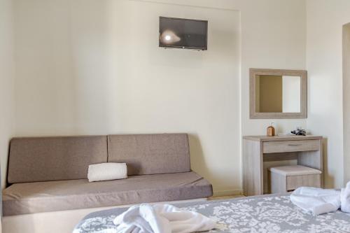 1 dormitorio con 1 cama y TV en la pared en Blue Lagoon, en Amoudi