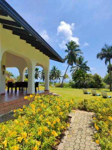 a pavilion with a table and yellow flowers at Villa Luana Yuna in Au Cap