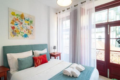 um quarto com uma cama grande com almofadas vermelhas e azuis em Porto River House no Porto