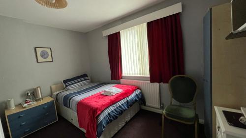 a bedroom with a bed and a chair and a window at The Great Western B&B in Paignton