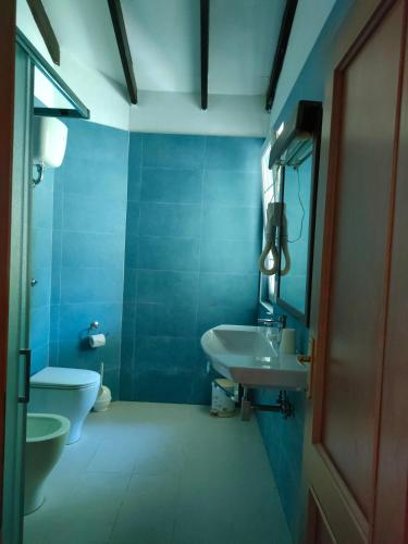 a blue bathroom with a sink and a toilet at Villa Luana Yuna in Au Cap