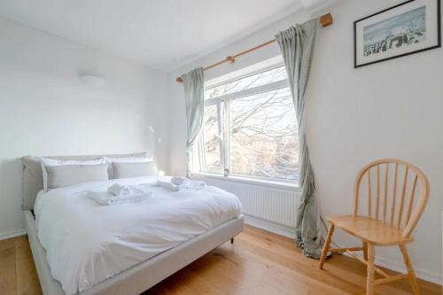 En eller flere senger på et rom på Peaceful 2 Bedroom Flat with Roof Terrace - Hackney