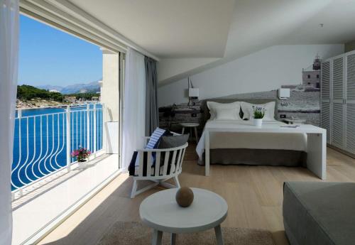 a living room with a bed and a large window at Hotel Osejava in Makarska