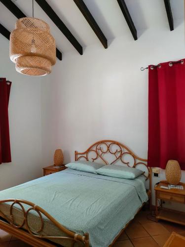 a bedroom with a bed and a red curtain at Villa Luana Yuna in Au Cap